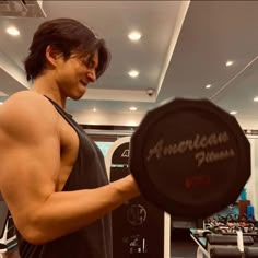 a man holding up a black disc in a gym