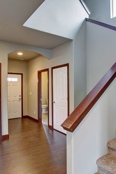 an empty house with stairs leading up to the front door and another room in the back