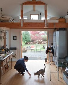 before and after photos of a house being remodeled with wood flooring, the cat is walking in front of the garage door