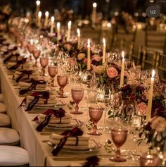 a long table is set with wine glasses and candles