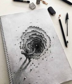 a spiral notebook with an image of a person in the middle and pencils next to it