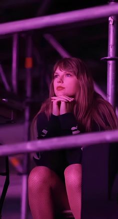 a woman is sitting on a chair with her hand under her chin and looking off to the side