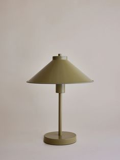 a lamp that is sitting on top of a table next to a white wall and floor