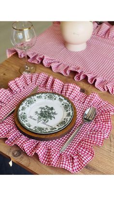 there is a plate and silverware on the table with pink gingham placemats