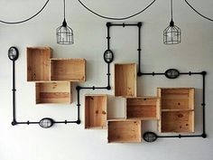 a bunch of wooden boxes hanging on a wall next to a light fixture with wires