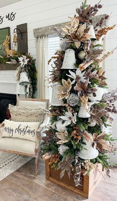 a decorated christmas tree in a living room with white and gold decorations on the top