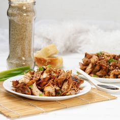 two white plates filled with food on top of a bamboo mat next to a glass jar