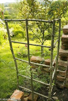 a stone wall made out of sticks in the grass