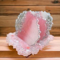 a pink and white object sitting on top of a wooden table