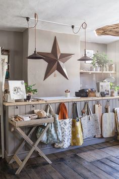 the shop has many bags hanging on the wall and two large star lights above it