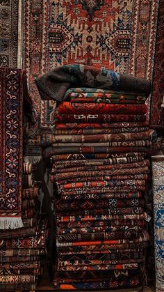 a pile of rugs sitting on top of each other in front of a wall