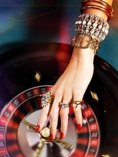 a woman's hand on top of a roule with gold rings and bracelets