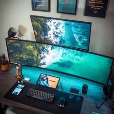 a desk with two monitors and a keyboard on it