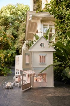 a doll house is shown in front of some trees