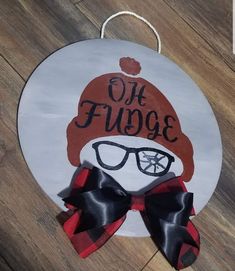 a sign that says oh fudge with glasses and a red hat on the front