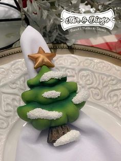 a green christmas tree sitting on top of a white plate