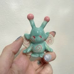 a person holding a small toy in their hand