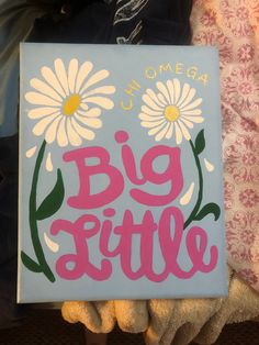 someone holding up a sign that says,'big little'with daisies on it