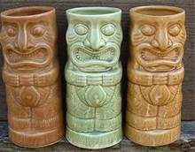 three ceramic tiki mugs sitting next to each other