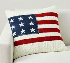 an american flag knitted pillow on a white couch