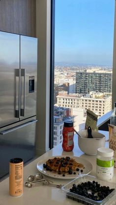 the kitchen counter is covered with cookies and other food items, along with a view of the city