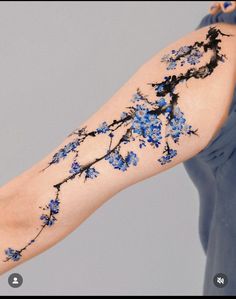 a woman's arm with blue flowers painted on it