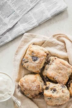 blueberry muffins on a napkin next to a glass of milk