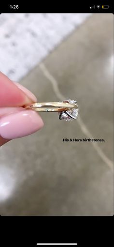 a person holding a gold ring with a diamond in it's center and the words he & her birthdays written on it