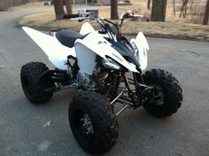 a white four - wheeler is parked on the street