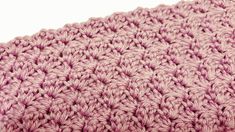 a close up view of a pink crocheted blanket