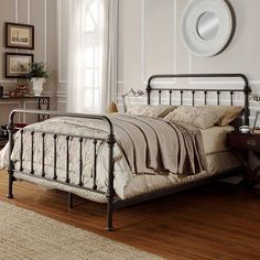 a bedroom with a bed, dresser and mirror on the wall next to hardwood flooring