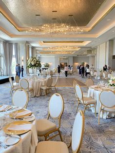 a banquet hall with tables and chairs set up for an event or function, people are standing in the background