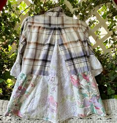 a white shirt with floral print on it sitting on top of a wicker table