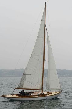 a sailboat with two people on it in the water