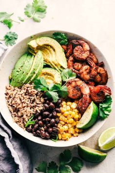 a bowl filled with rice, beans, avocado, shrimp and cilantro