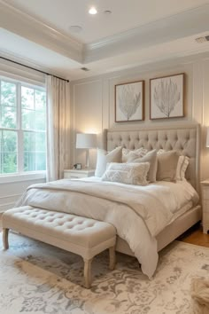 a large white bed sitting in a bedroom next to two lamps on either side of a window