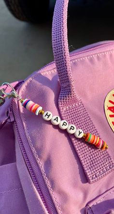 a pink bag with a name beaded on it and a car in the background