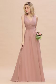 a woman in a long pink bridesmaid dress standing with her hand on her hip