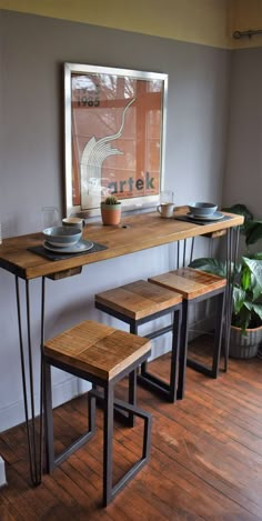 a wooden table with two benches next to it and a potted plant in the corner