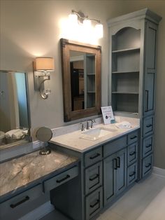 a large bathroom with double sinks and cabinets in it's own area, along with a mirror on the wall