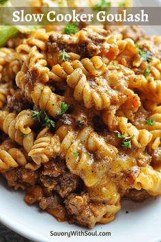 a white plate topped with pasta and meat