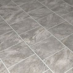 a white toilet sitting in a bathroom next to a gray tiled wall and flooring