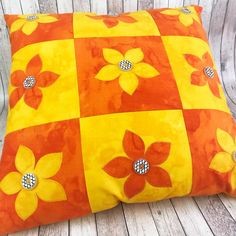 an orange and yellow pillow with flowers on it