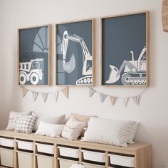 three framed pictures hang on the wall above a bench with pillows and storage bins