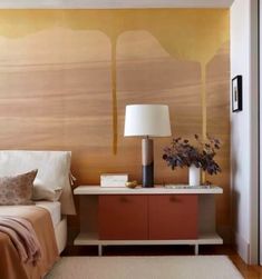 a bedroom with a bed, nightstand and painting on the wall behind it's headboard