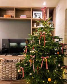 a decorated christmas tree in front of a television