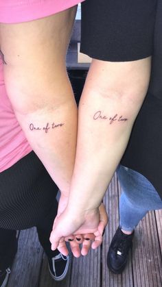 two people holding hands with the words one of them written in cursive font