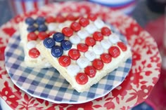 a red, white and blue cake with buttons on it is sitting on a plate