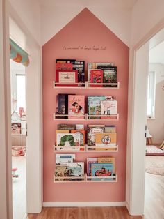 there is a pink wall with books on it