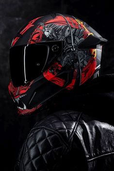 a person wearing a motorcycle helmet and black leather jacket in front of a dark background